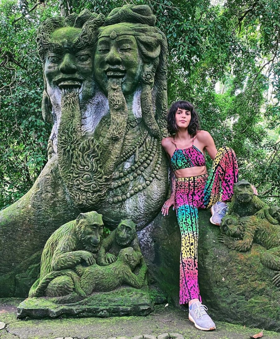 Bright clothes beside a carved sculpture